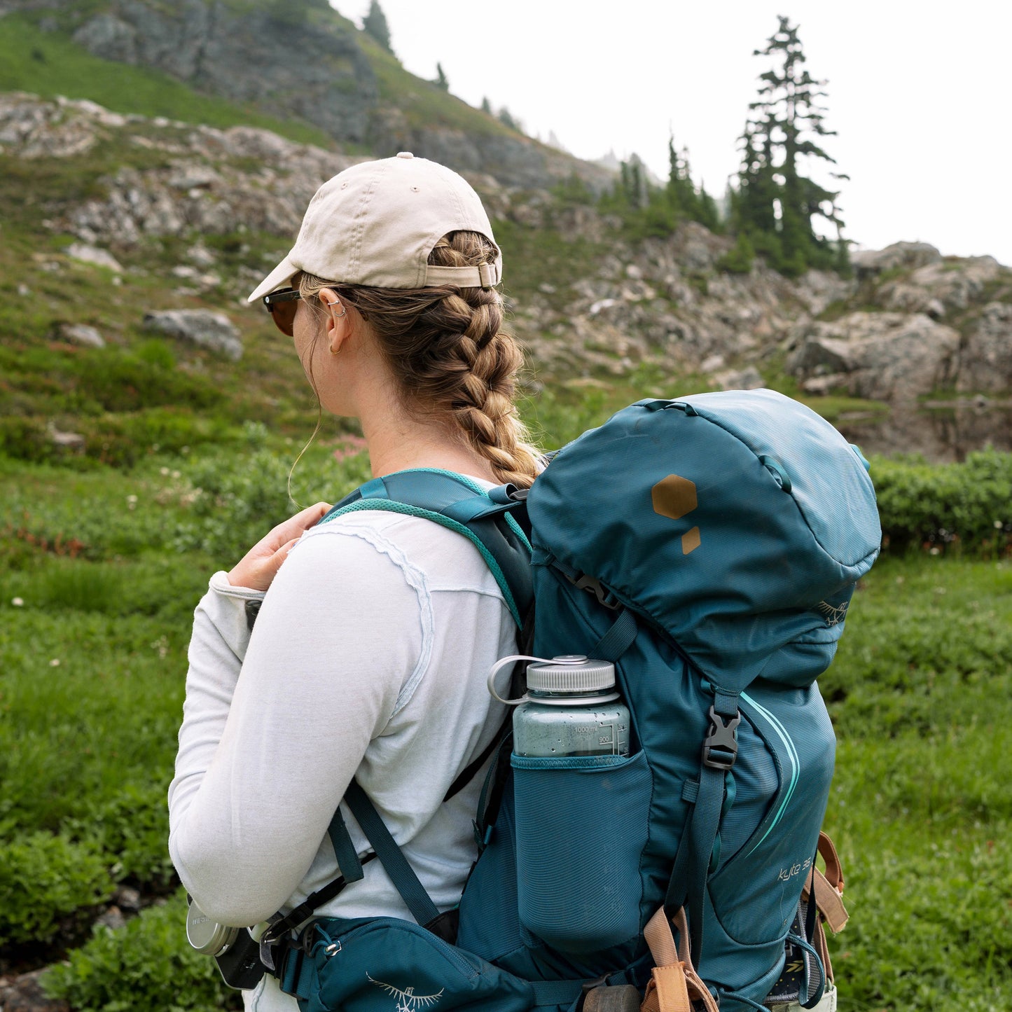 Person with a large blue backpack hiking in a mountainous area